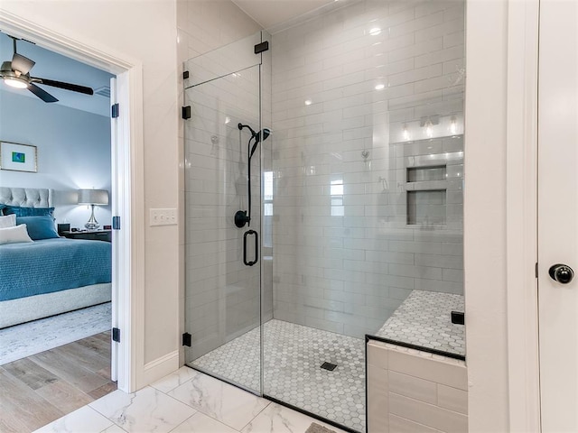 bathroom with a ceiling fan, baseboards, marble finish floor, a stall shower, and ensuite bath