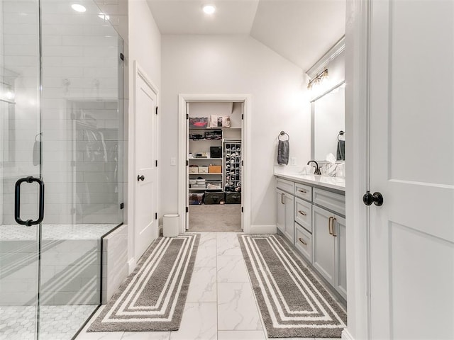 full bath with lofted ceiling, vanity, marble finish floor, a stall shower, and a walk in closet