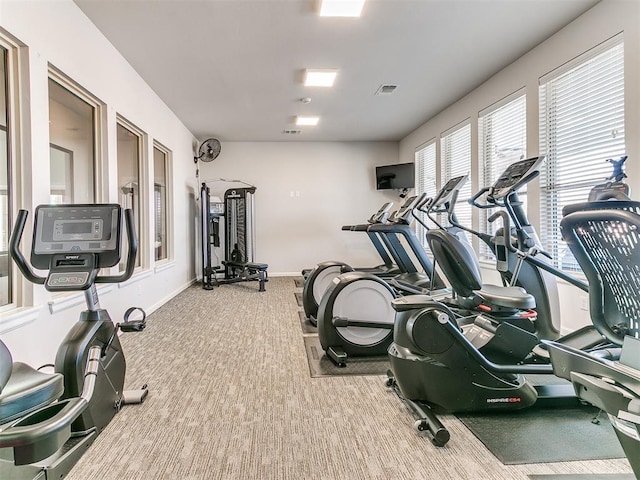 gym with carpet, visible vents, and baseboards