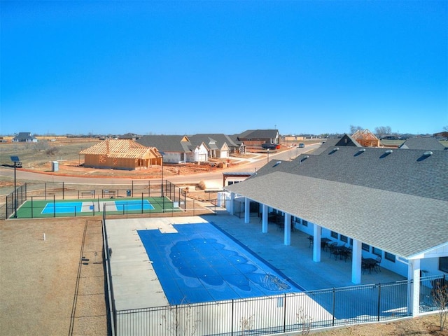 view of swimming pool featuring a residential view, fence, and a patio