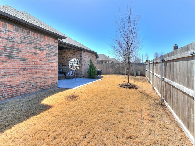 view of yard featuring central AC unit, a patio area, and a fenced backyard