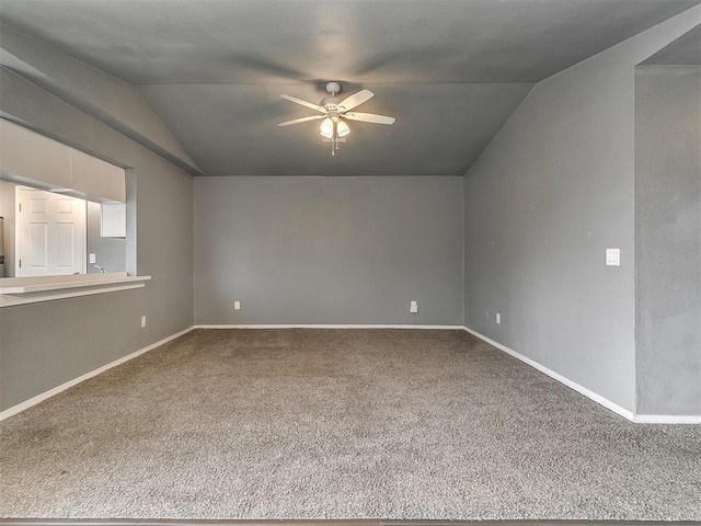 unfurnished room with lofted ceiling, ceiling fan, carpet floors, and baseboards