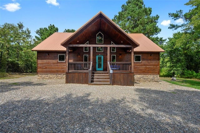 rustic home with covered porch and metal roof