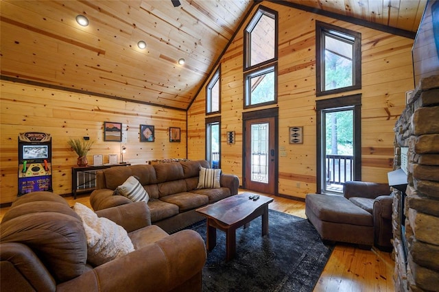 living room with light wood-type flooring, high vaulted ceiling, wooden ceiling, and wood walls