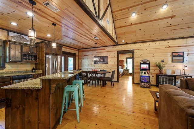 kitchen featuring light wood finished floors, stainless steel refrigerator, wood ceiling, dishwasher, and open floor plan