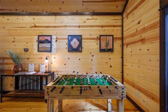 game room with wood walls and wood finished floors