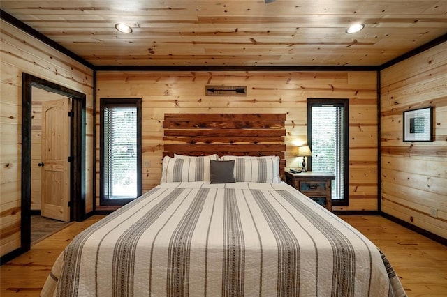 bedroom featuring light wood-style flooring, wood ceiling, wood walls, and multiple windows