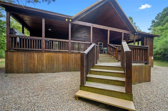 back of house featuring stairway and metal roof