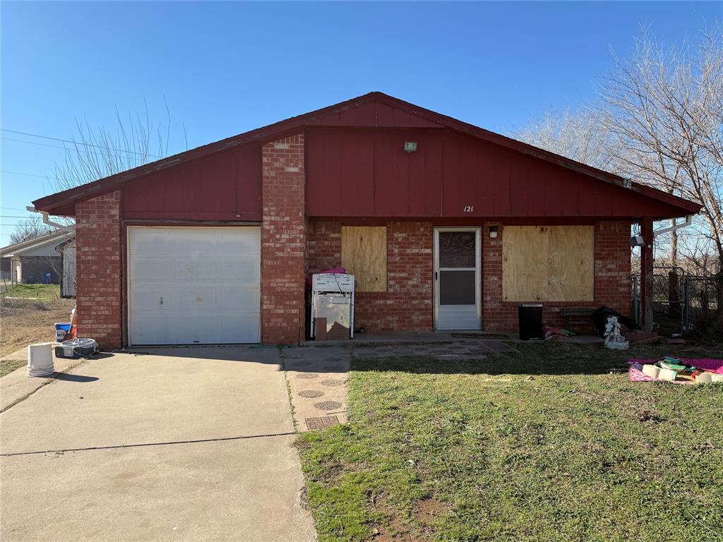 view of front of property with concrete driveway, brick siding, and a front lawn