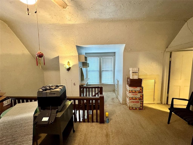 bedroom with lofted ceiling, carpet flooring, and a textured wall