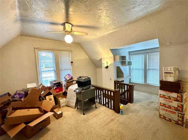 bonus room featuring lofted ceiling, carpet flooring, a textured wall, and a textured ceiling