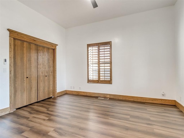 unfurnished bedroom featuring a ceiling fan, baseboards, and wood finished floors