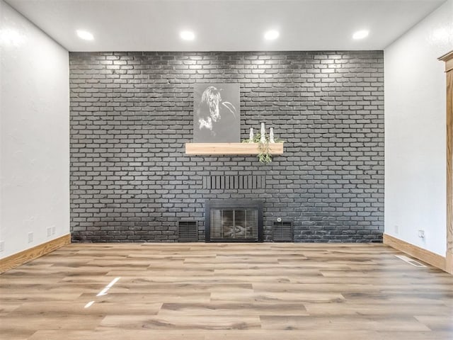 unfurnished living room featuring a fireplace, recessed lighting, wood finished floors, and baseboards