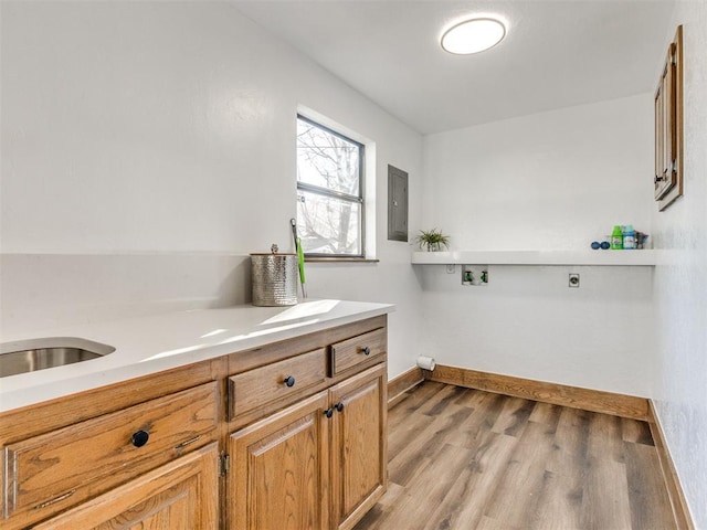 laundry room with hookup for an electric dryer, washer hookup, electric panel, cabinet space, and light wood finished floors