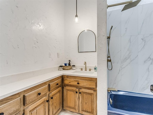 full bathroom featuring a textured wall, vanity, and a marble finish shower