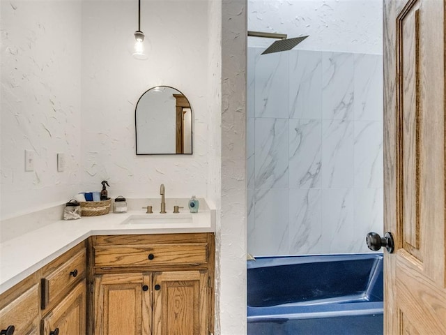 full bathroom featuring a textured wall, vanity, and a marble finish shower