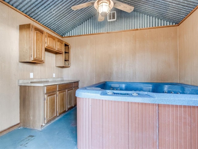 interior space featuring lofted ceiling, ceiling fan, concrete floors, and a hot tub