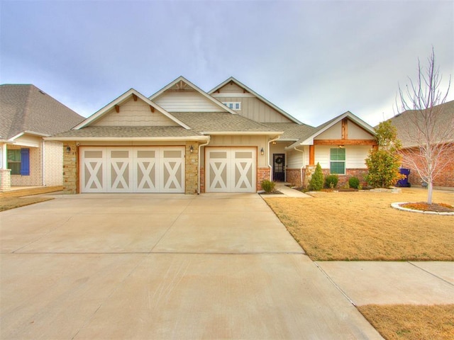 craftsman inspired home with driveway, a shingled roof, an attached garage, and stone siding