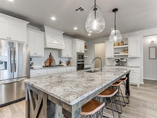 kitchen with open shelves, visible vents, appliances with stainless steel finishes, white cabinetry, and a sink