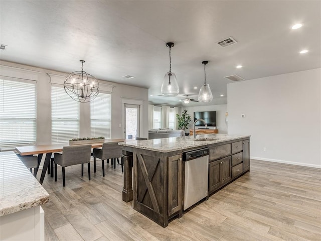 kitchen featuring stainless steel dishwasher, visible vents, and decorative light fixtures