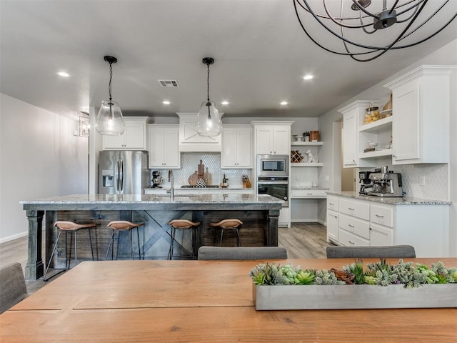 kitchen featuring a kitchen breakfast bar, open shelves, white cabinets, and stainless steel appliances