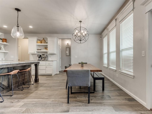 dining area with recessed lighting, baseboards, light wood finished floors, and an inviting chandelier