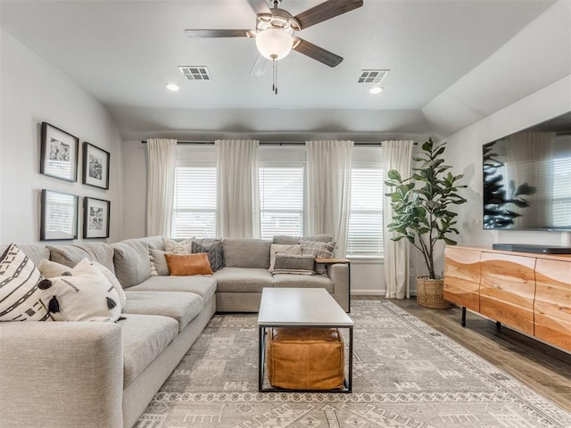 living room with vaulted ceiling, visible vents, and plenty of natural light