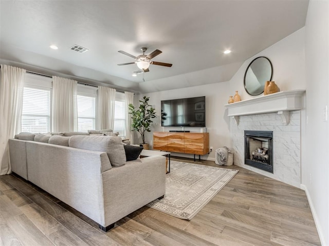 living area with baseboards, visible vents, wood finished floors, a fireplace, and recessed lighting