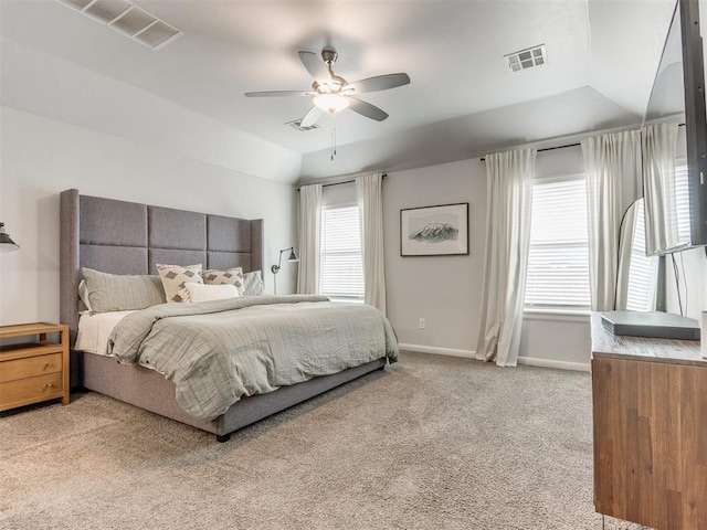 bedroom with carpet, visible vents, vaulted ceiling, multiple windows, and baseboards