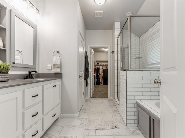 bathroom with visible vents, marble finish floor, a spacious closet, vanity, and a shower stall