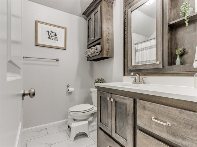 bathroom with marble finish floor, toilet, vanity, and baseboards