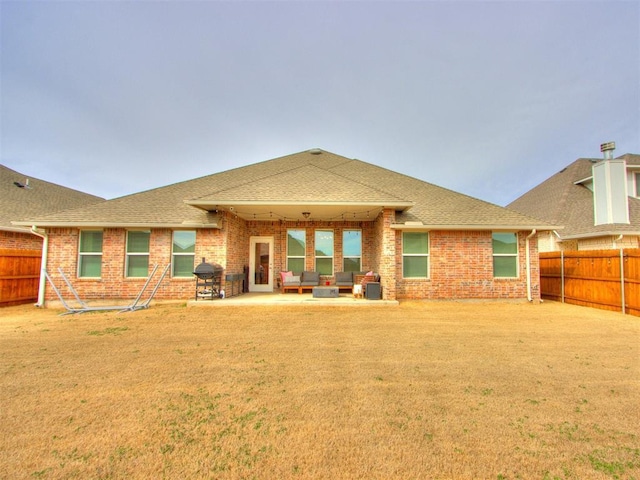 back of house featuring a patio area, a fenced backyard, roof with shingles, and brick siding