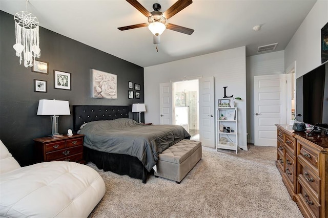 bedroom featuring ensuite bath, visible vents, a ceiling fan, and light colored carpet