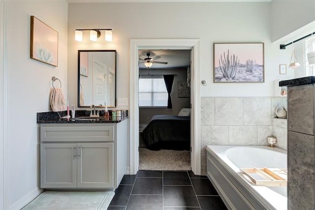 bathroom featuring ceiling fan, vanity, a bath, tile patterned floors, and ensuite bath