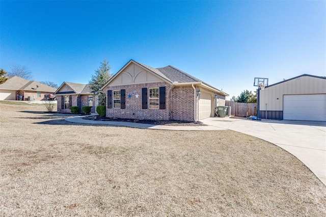 view of front facade with brick siding, fence, driveway, and a front lawn