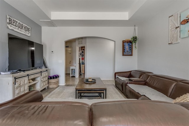 living area featuring arched walkways and wood finished floors