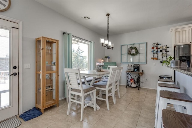 dining room featuring light tile patterned floors, visible vents, and a chandelier