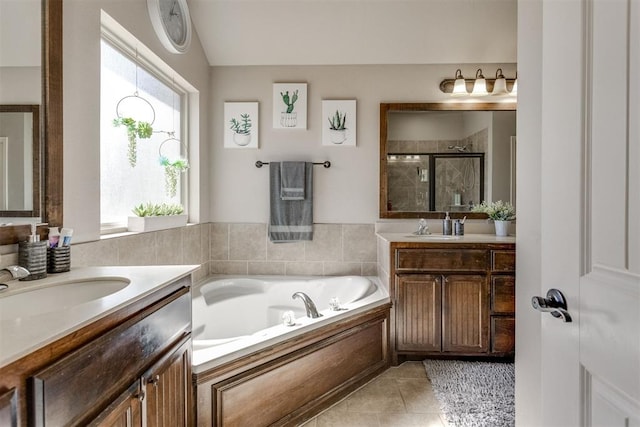 full bathroom featuring a sink, a stall shower, tile patterned flooring, and a bath