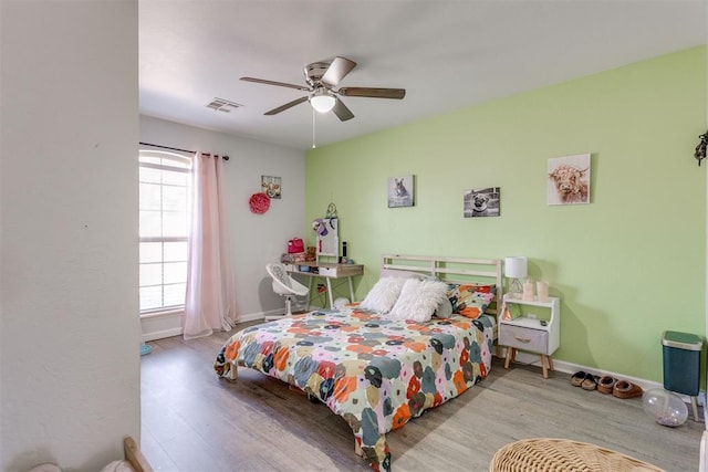 bedroom with visible vents, ceiling fan, baseboards, and wood finished floors