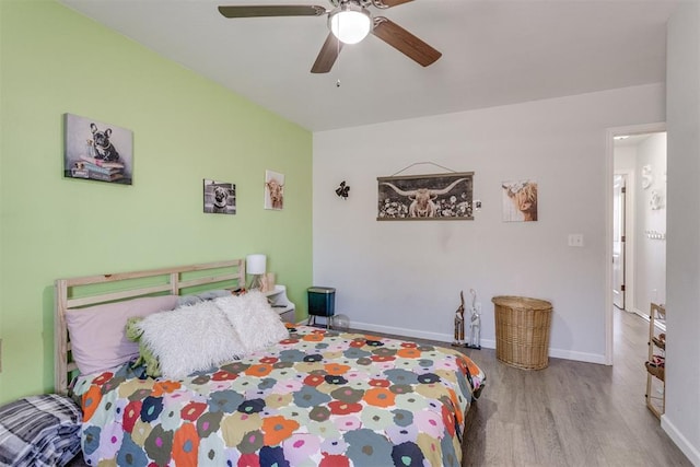 bedroom featuring wood finished floors, a ceiling fan, and baseboards