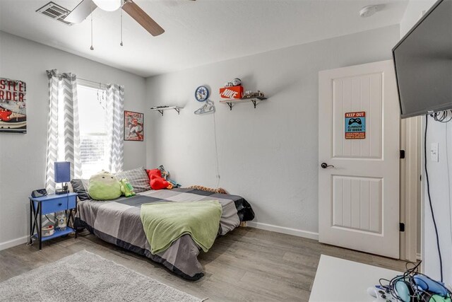 bedroom with visible vents, baseboards, ceiling fan, and wood finished floors