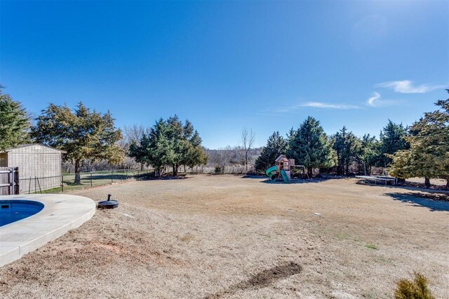 view of yard featuring playground community and fence