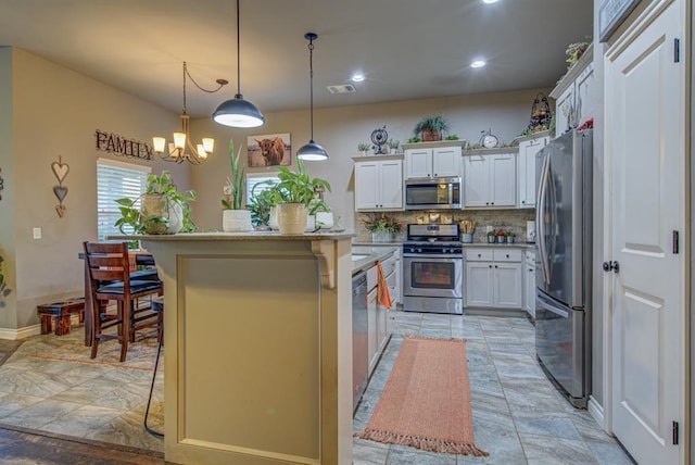 kitchen with a center island, a breakfast bar, stainless steel appliances, visible vents, and white cabinetry