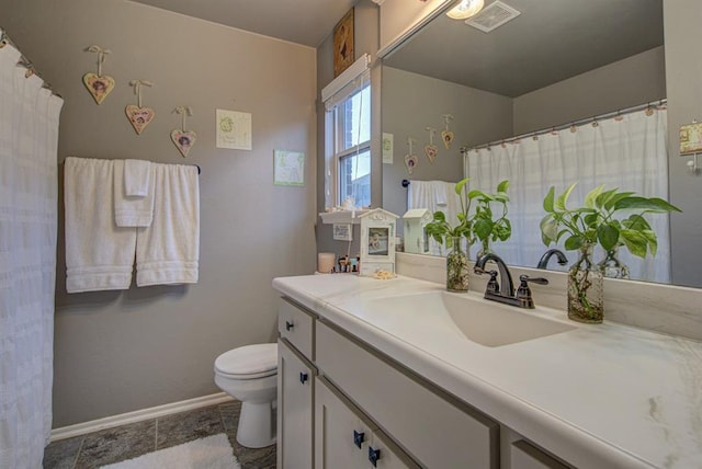 bathroom featuring toilet, baseboards, visible vents, and vanity