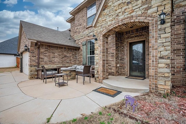 view of patio with an attached garage, driveway, and an outdoor living space