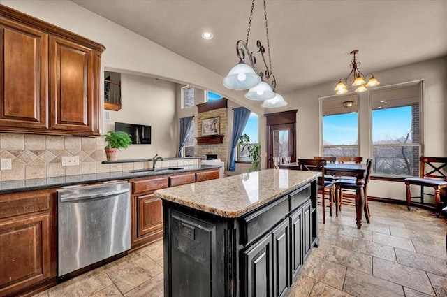 kitchen featuring decorative backsplash, dishwasher, brown cabinets, a center island, and a sink