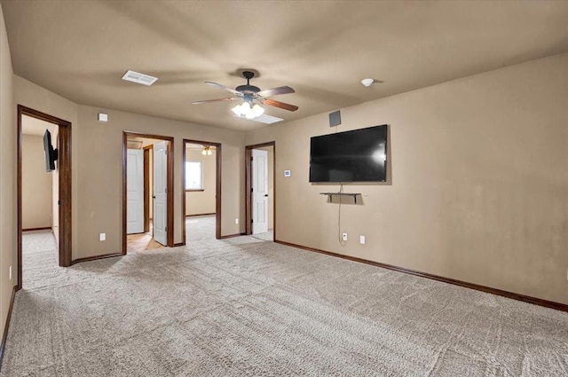 unfurnished living room featuring light colored carpet, ceiling fan, visible vents, and baseboards