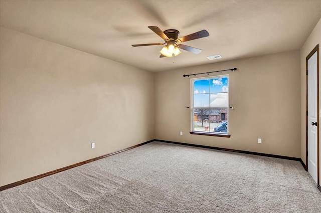 carpeted empty room featuring a ceiling fan, visible vents, and baseboards