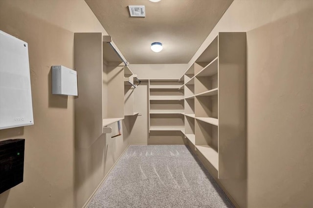 walk in closet featuring visible vents and dark carpet