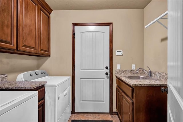 washroom featuring cabinet space, a sink, and separate washer and dryer